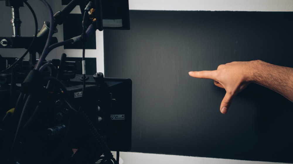 Persona acostada en la cama cerca de un televisor de pantalla plana negra