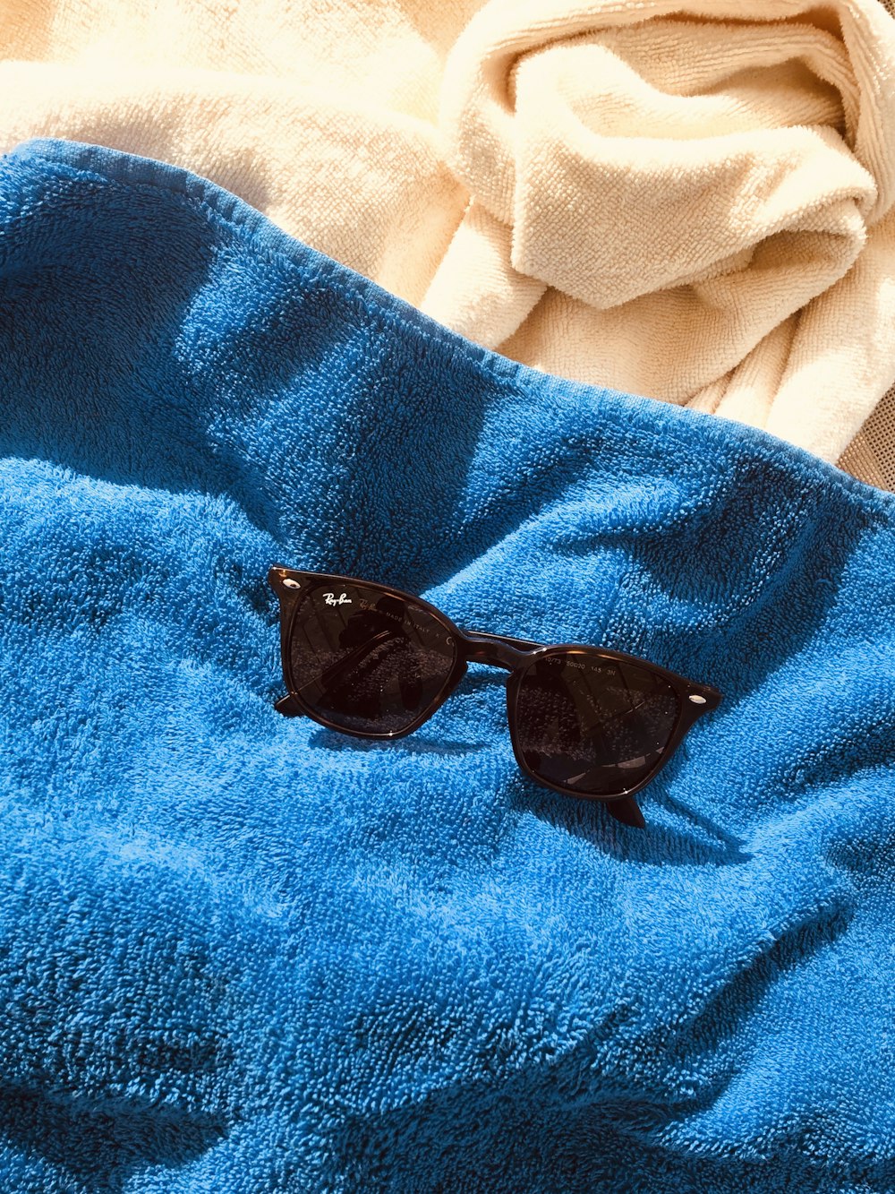 black framed sunglasses on blue textile