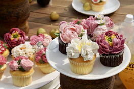 An assortment of colorful cupcakes arranged on a rustic wooden table.