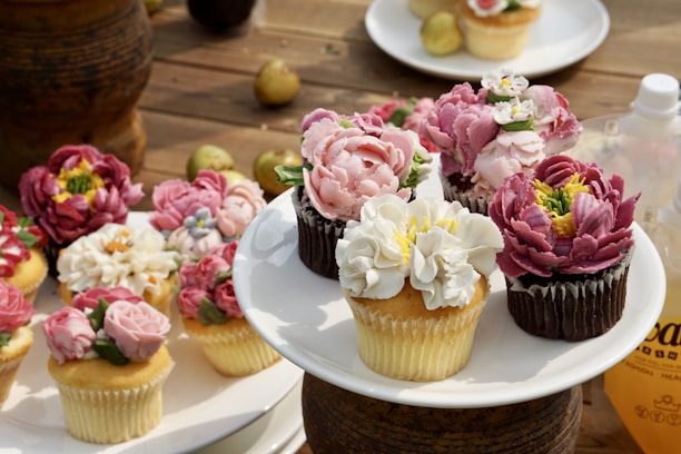 Close-up of a colorful assortment of decorated cupcakes with creamy toppings.