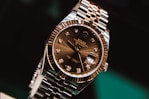 silver and gold round analog watch at 10 10