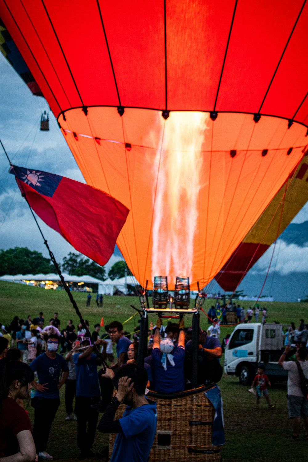 people in a park with red hot air balloons during daytime