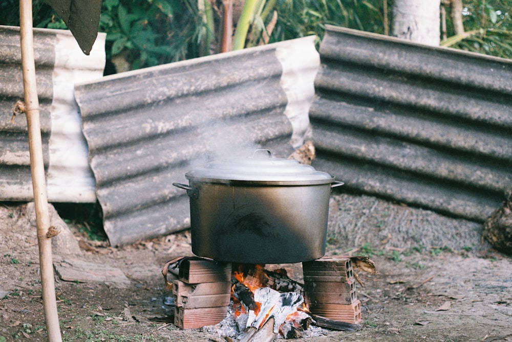 bollitore nero in fiamme vicino al muro di mattoni marroni