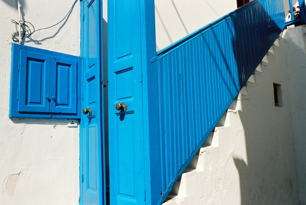 blue wooden door with white wall