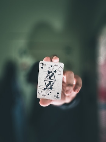 Close-up of a player’s hand selecting a powerful spell card with glowing hieroglyphs.