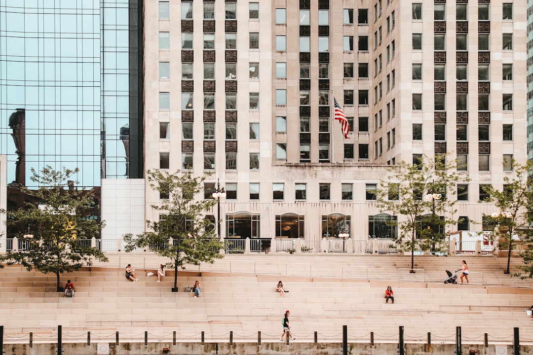 people walking on park near white concrete building during daytime