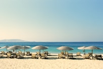 white and blue beach chairs on beach during daytime