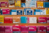 A variety of colorful maps and travel guides are displayed on wooden shelves. The maps are arranged in an orderly manner, with different sizes and titles visible, including Ordnance Survey maps and others for locations like France, Norwich, and Bournemouth.