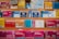 A variety of colorful maps and travel guides are displayed on wooden shelves. The maps are arranged in an orderly manner, with different sizes and titles visible, including Ordnance Survey maps and others for locations like France, Norwich, and Bournemouth.