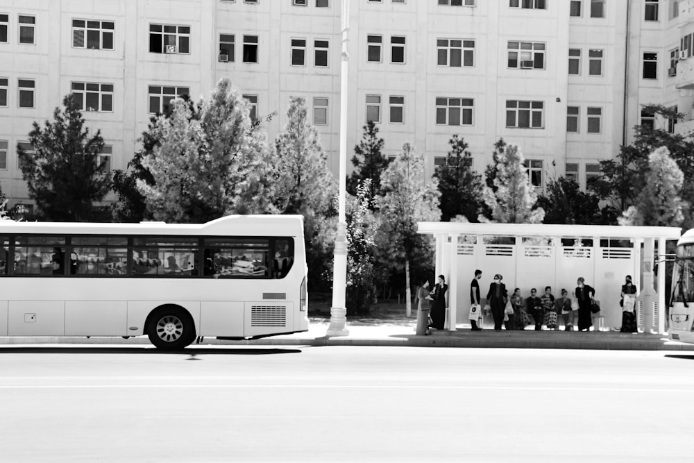 grayscale photo of white bus on road