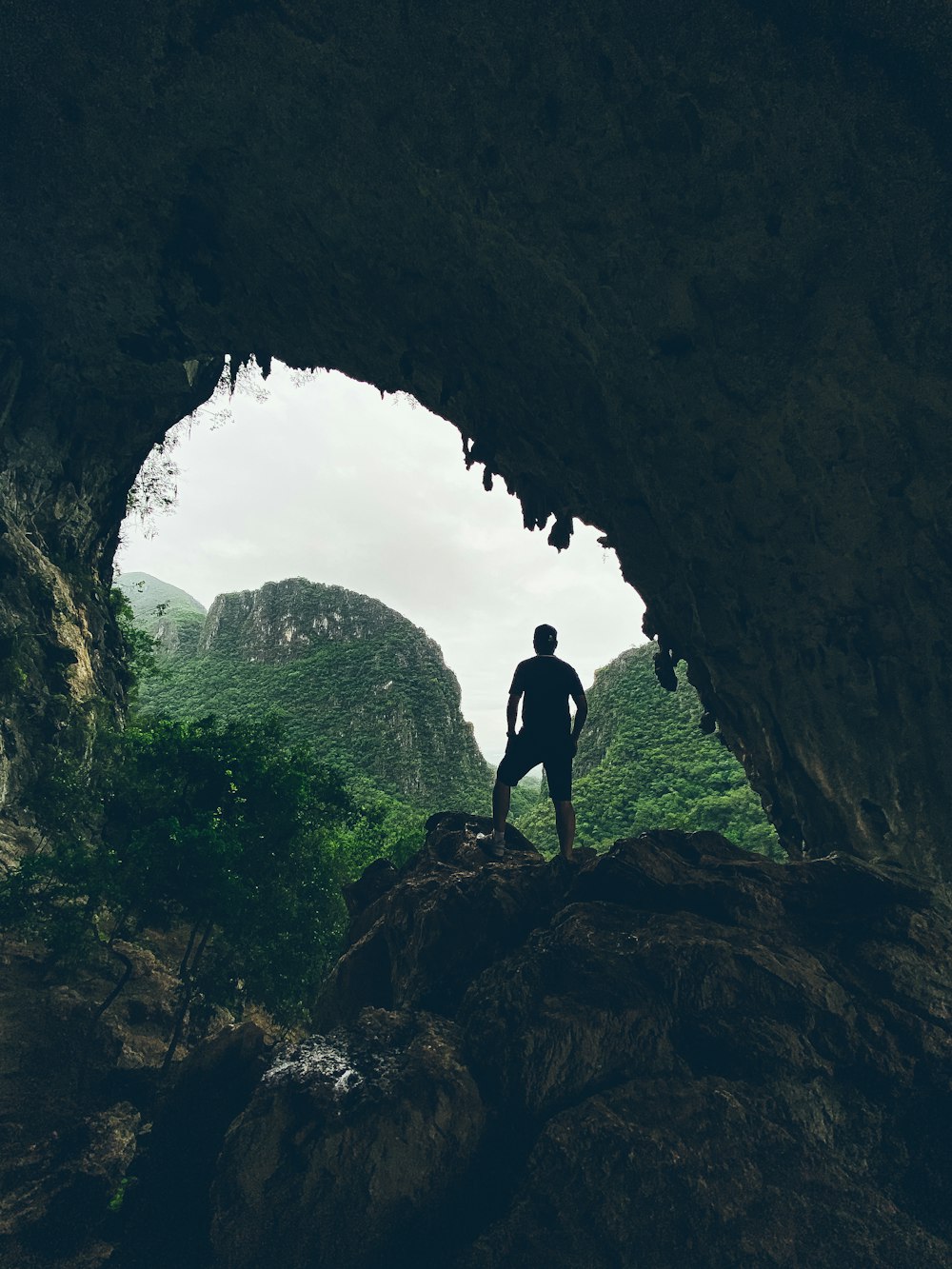 man in black shirt standing on rock formation during daytime