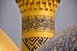 Close-up of intricate gold leaf details on a mosque pulpit.