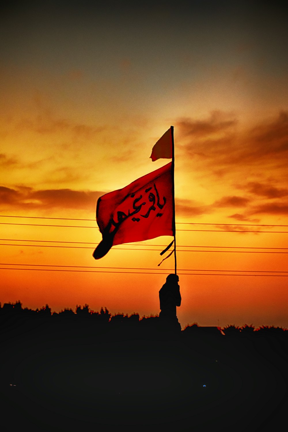 Un drapeau rouge flottant dans les airs au coucher du soleil