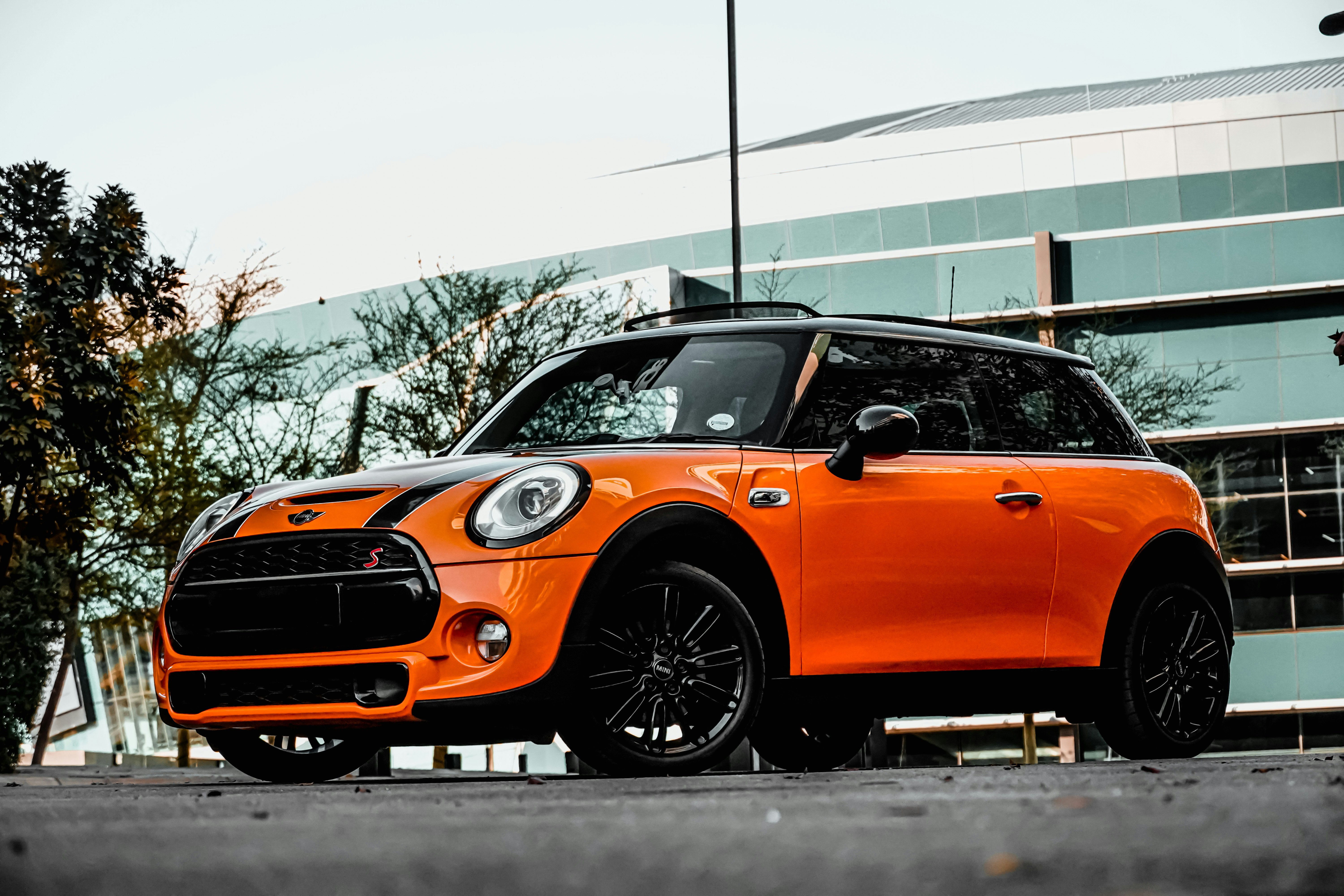 orange car on gray asphalt road during daytime