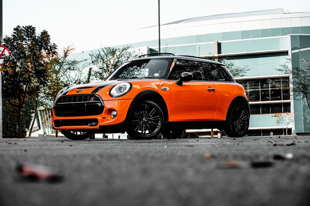 orange car on gray asphalt road during daytime