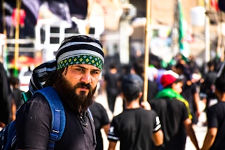 man in blue jacket wearing green and white hat