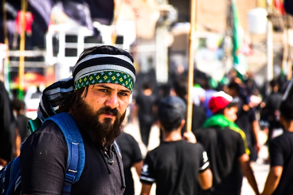 man in blue jacket wearing green and white hat