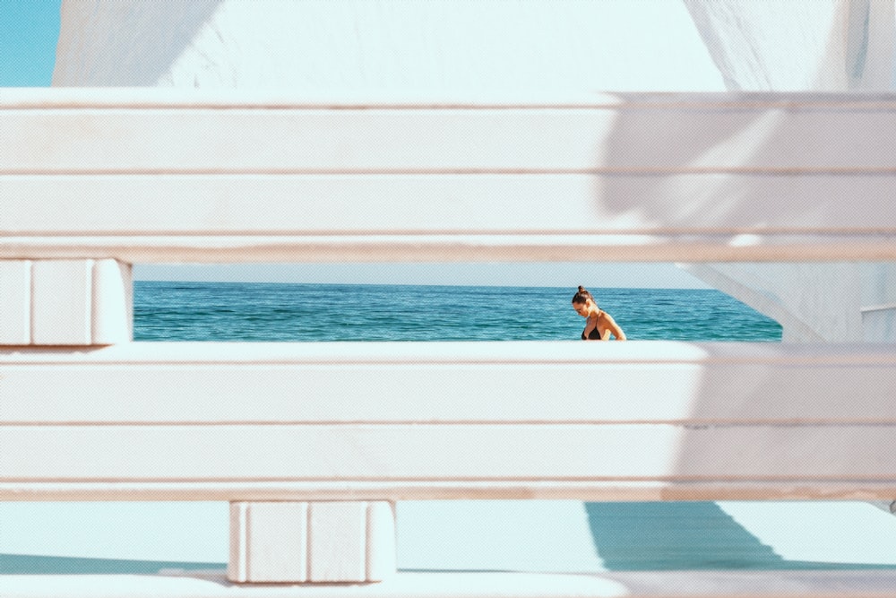 woman in white shirt sitting on white concrete bench