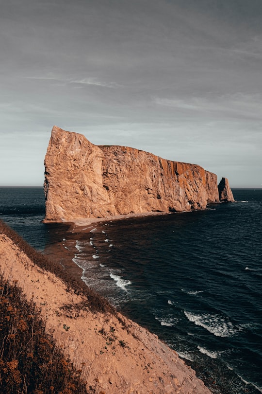 brown rock formation beside body of water during daytime in Percé Rock Canada