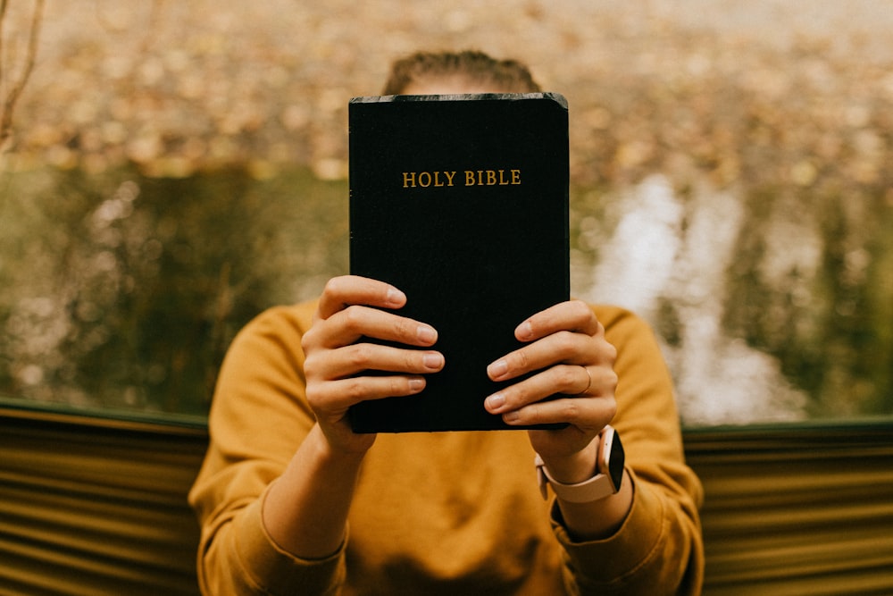 person holding black book during daytime