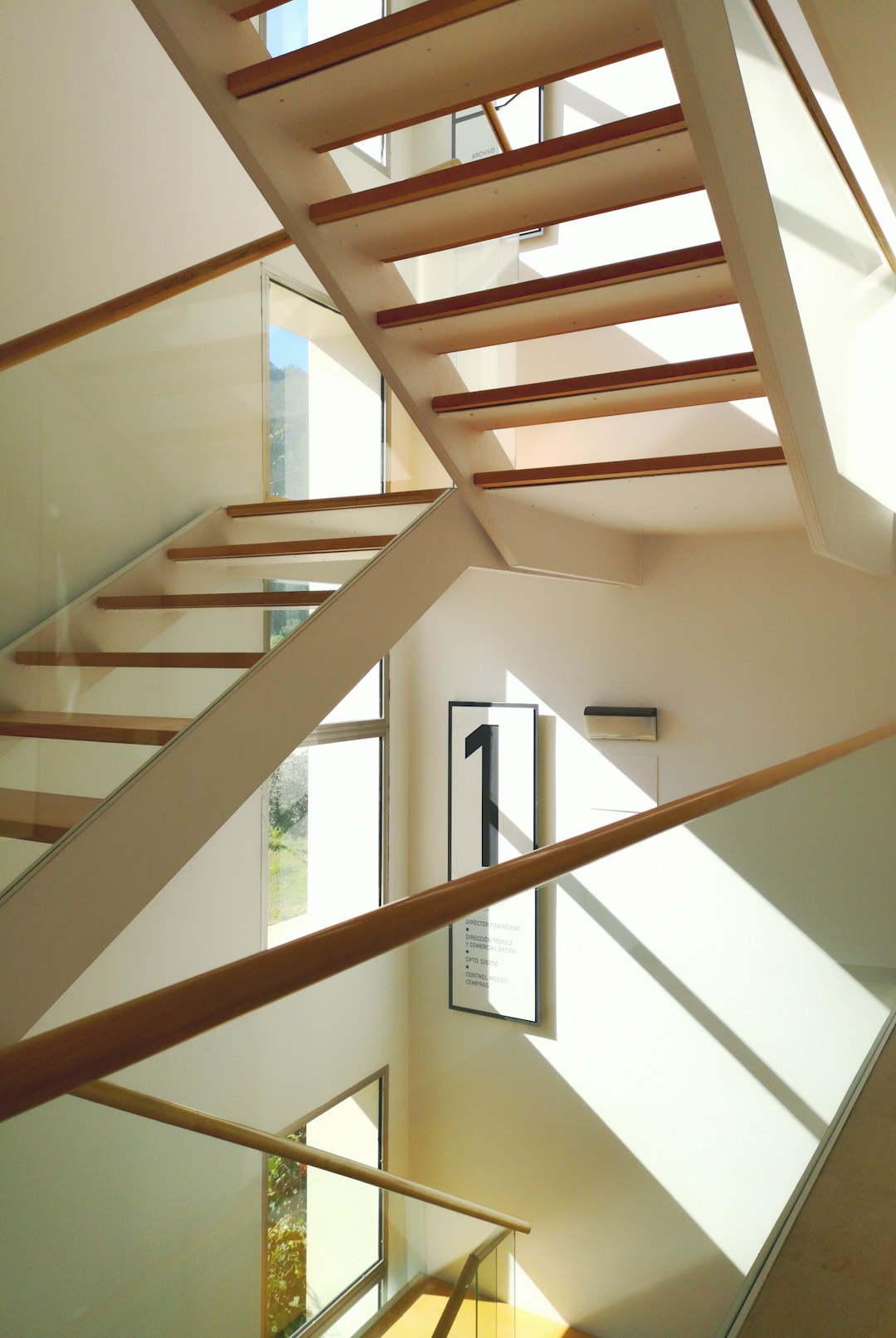 brown wooden staircase near white wall