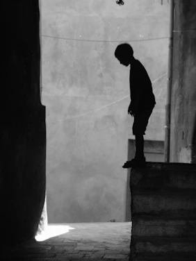 man in black long sleeve shirt and pants standing on concrete wall