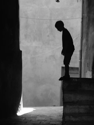 man in black long sleeve shirt and pants standing on concrete wall