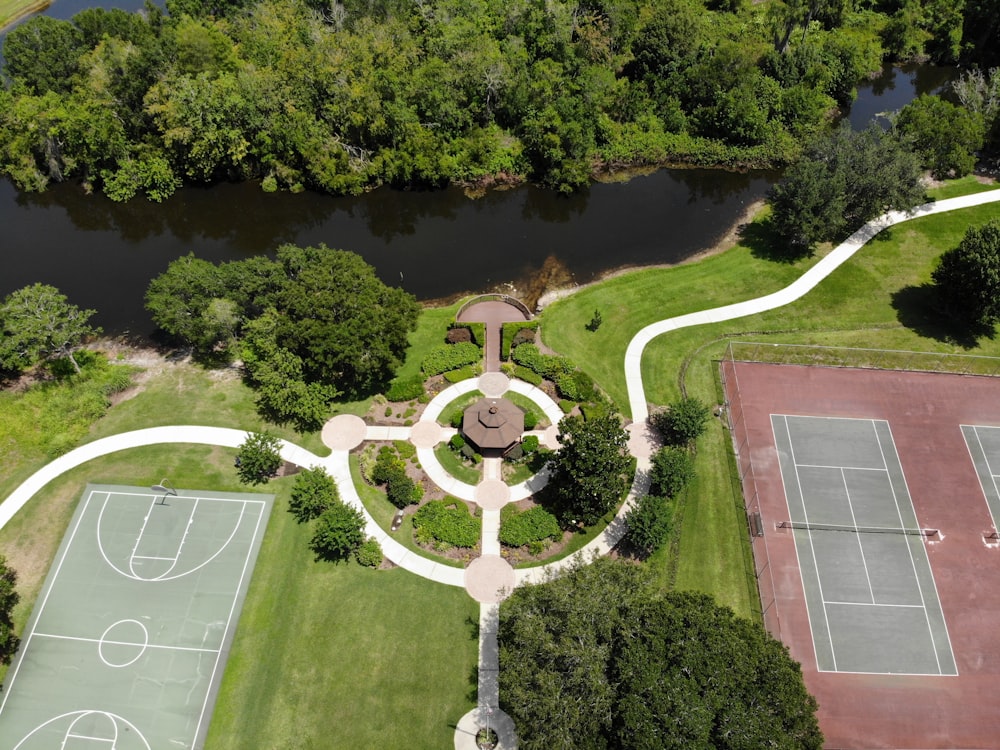 aerial view of green trees and brown concrete pathway