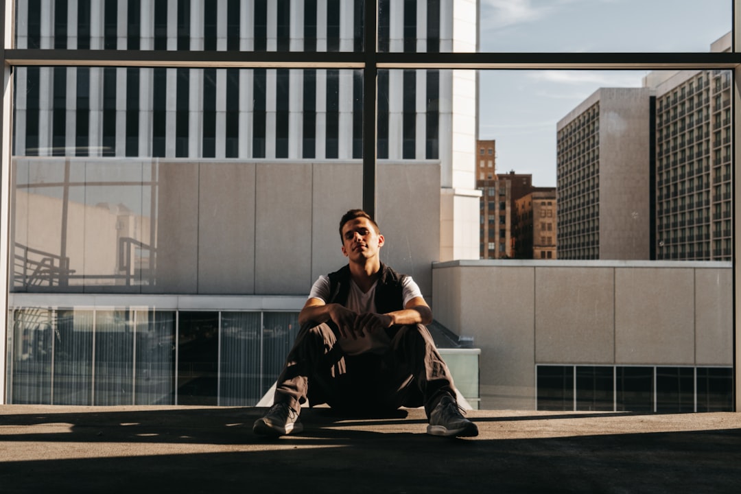 man in black jacket sitting on the floor