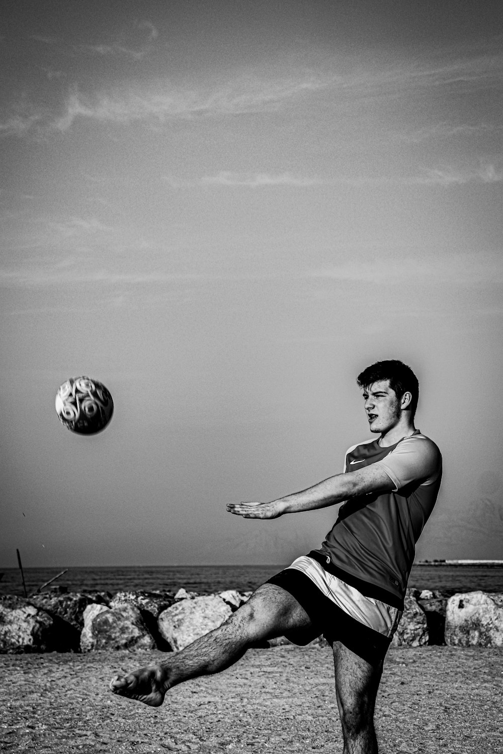 woman in tank top and shorts holding a soccer ball in grayscale photography