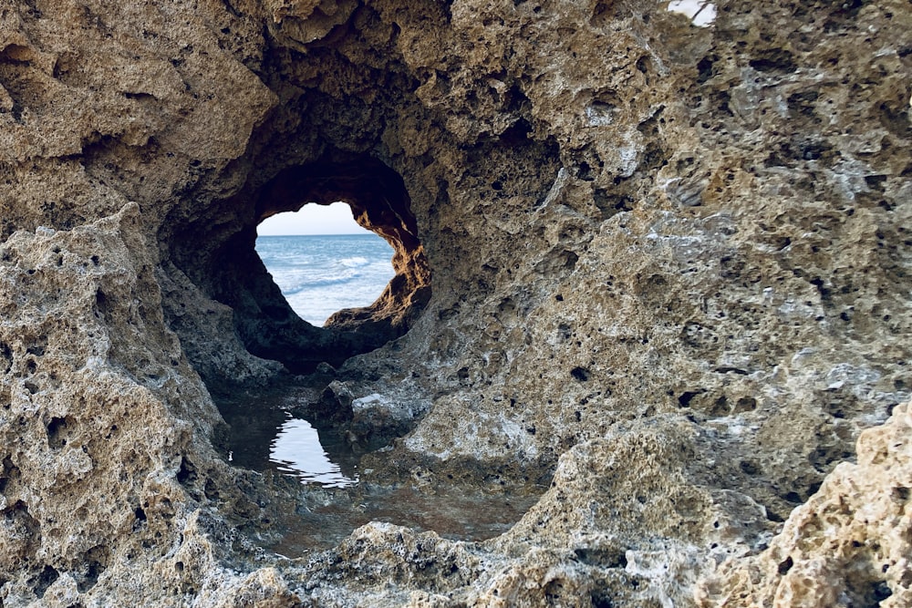 brown rock formation on body of water during daytime