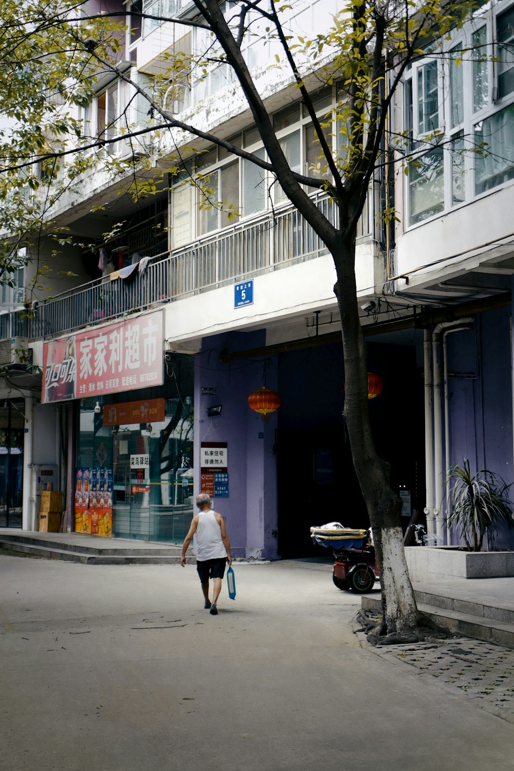 woman in white coat walking on sidewalk during daytime