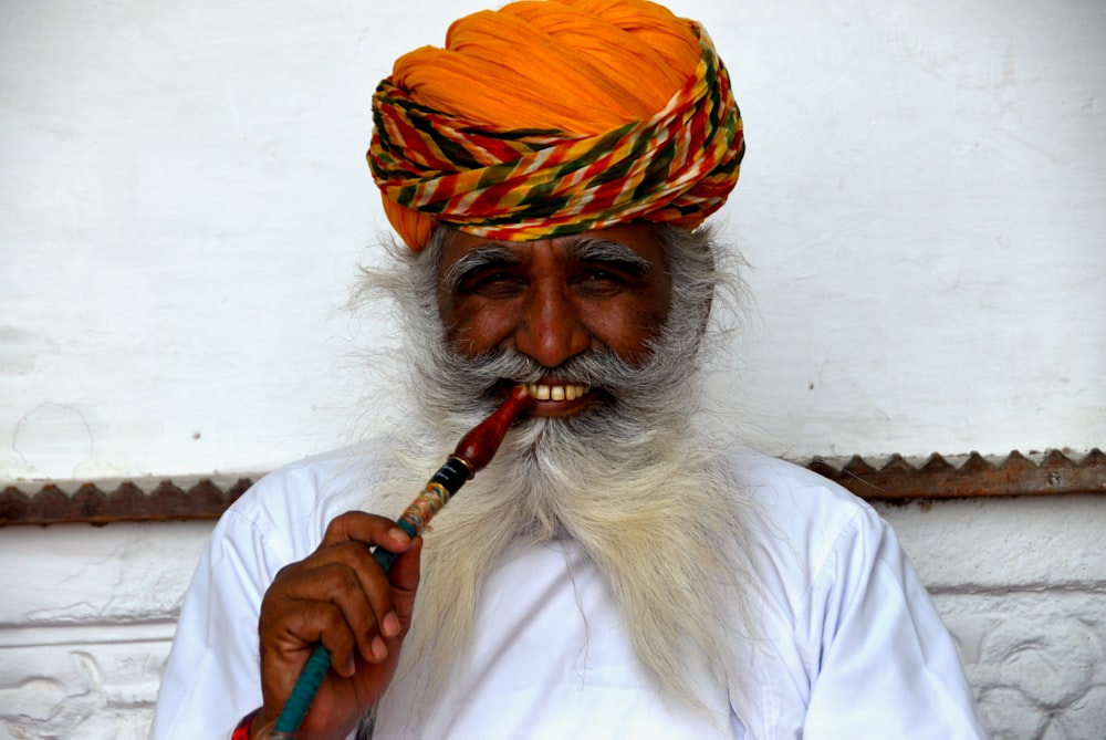 a man in a turban with a pipe in his mouth