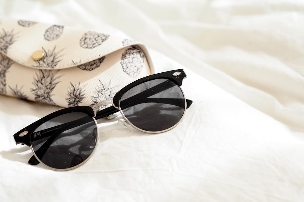 black framed sunglasses on white and brown floral textile