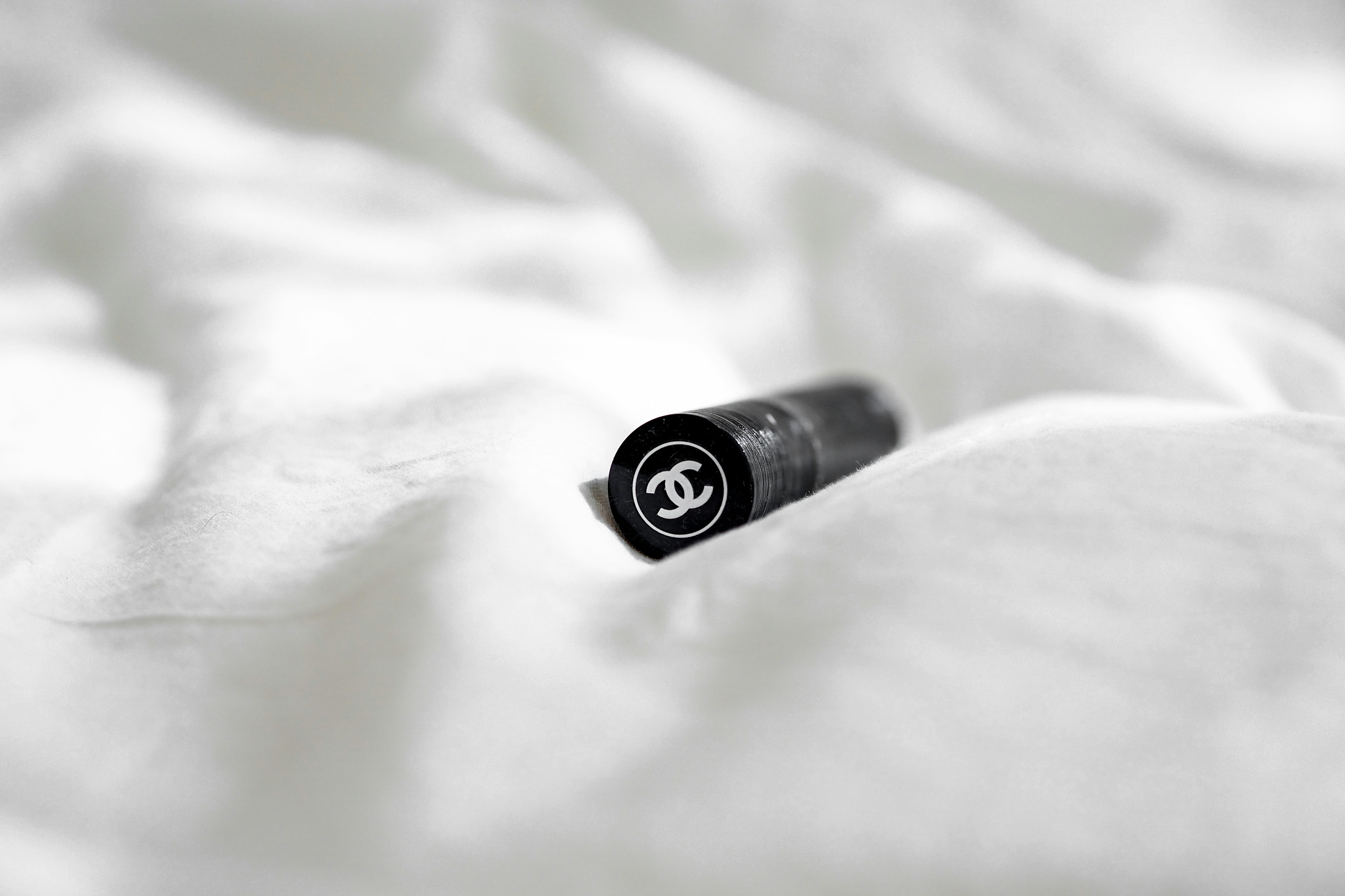 black and silver bottle on white textile