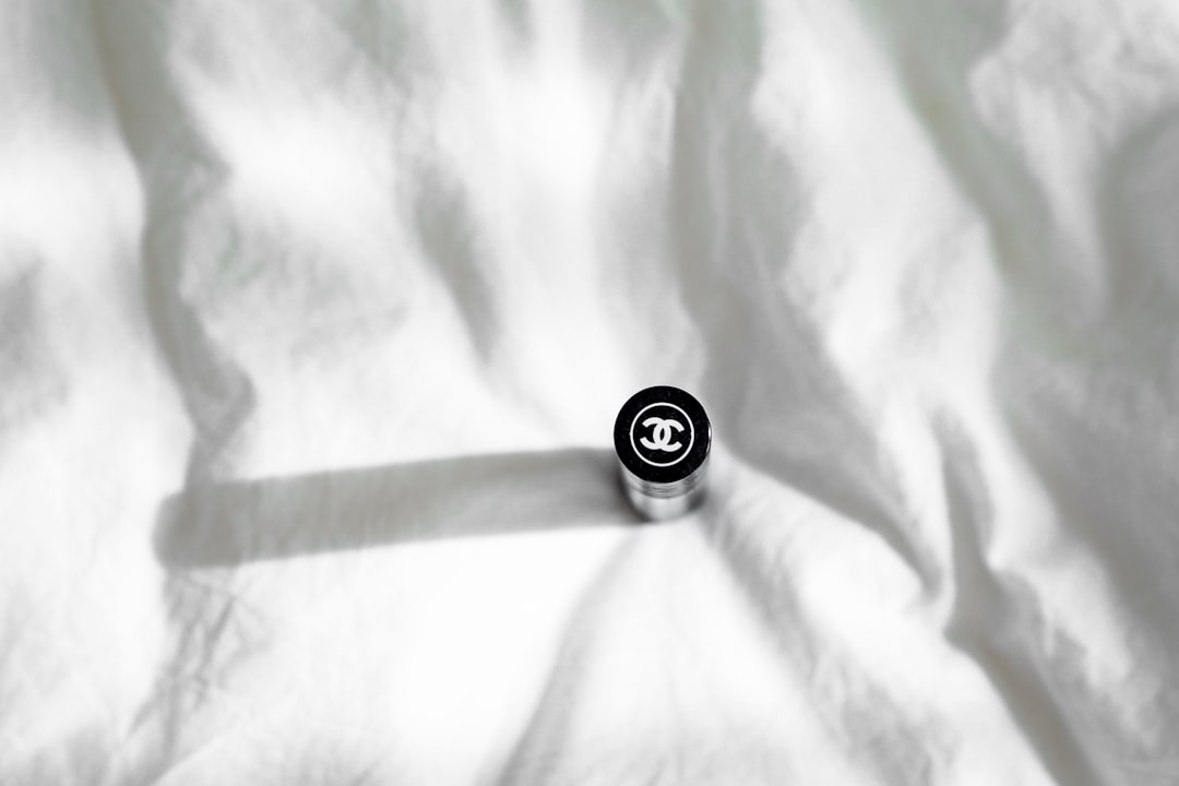 silver round coin on white textile