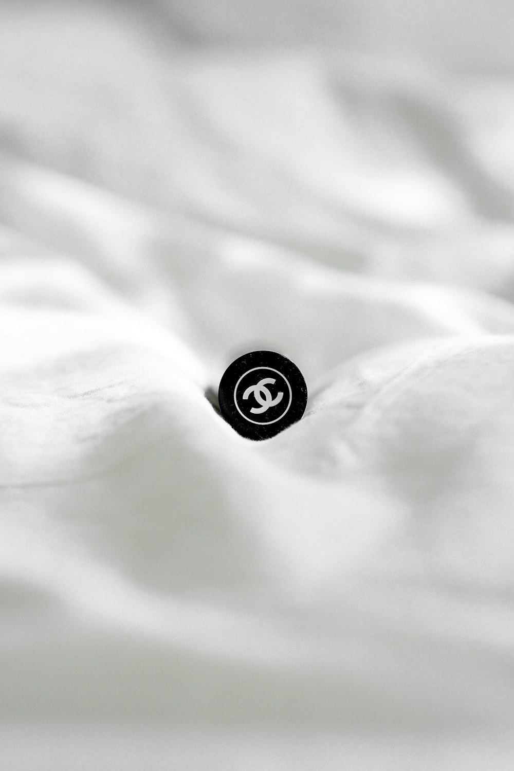 black round button on white textile