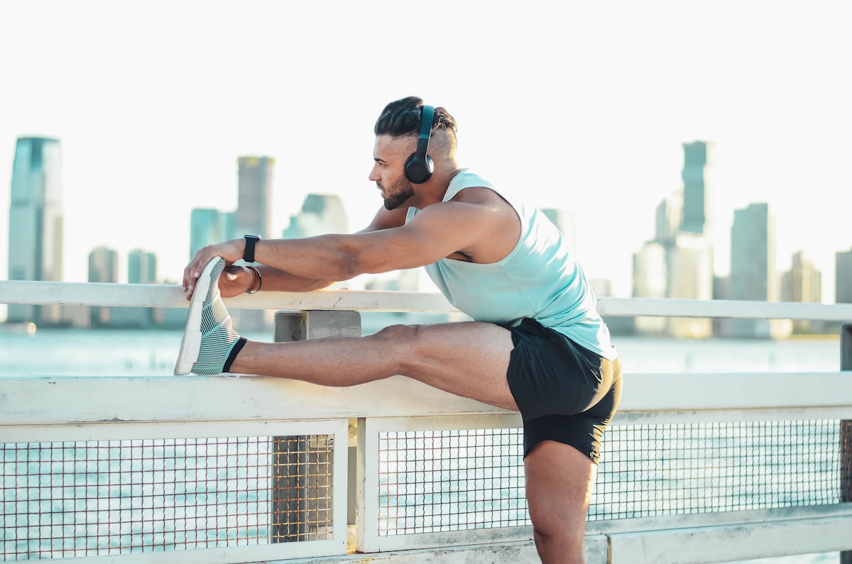 Man stretching hamstring outdoors as part of a morning routine for back support