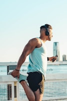 man in white tank top and black shorts wearing black sunglasses
