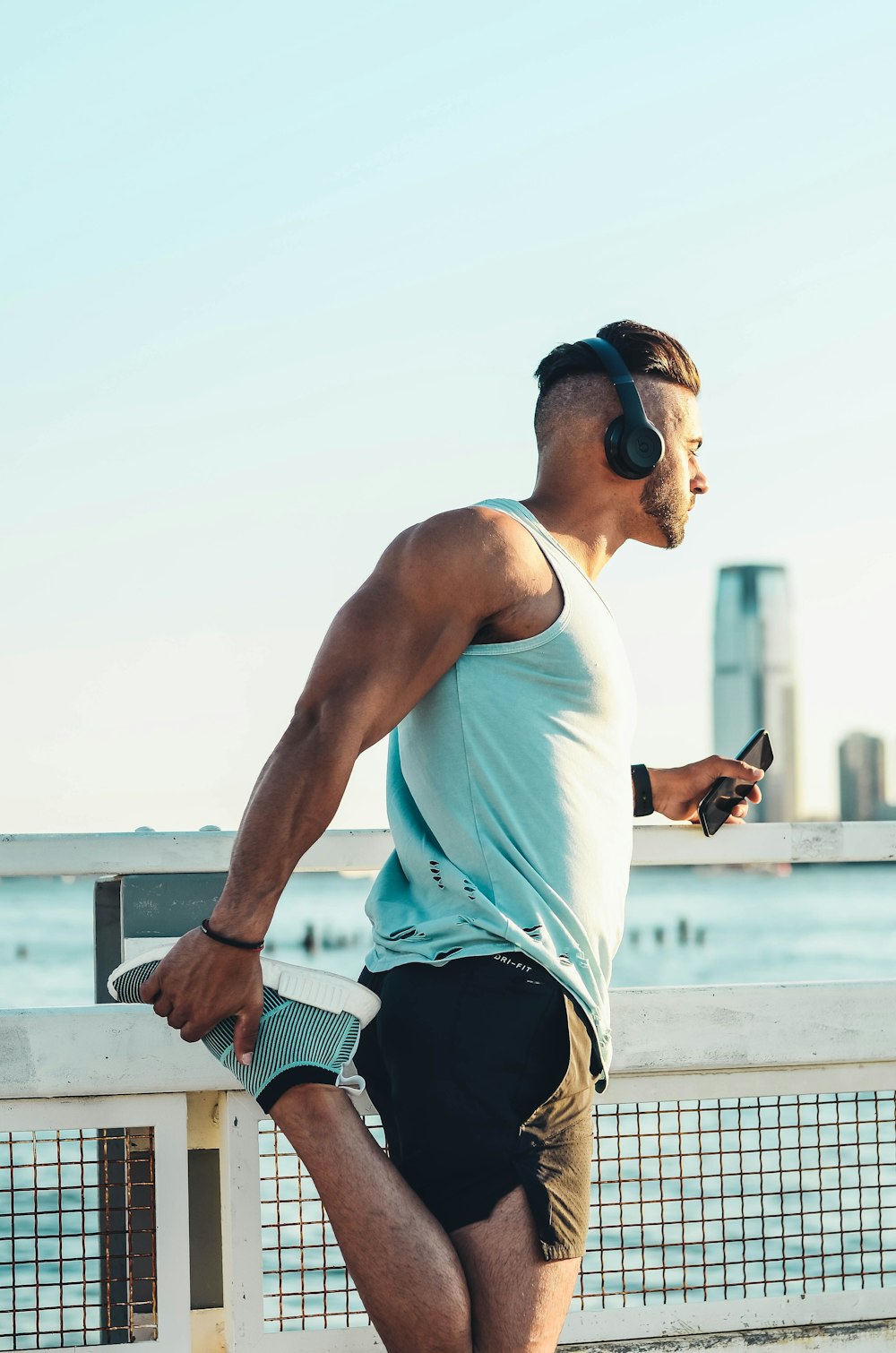 man in white tank top and black shorts wearing black sunglasses