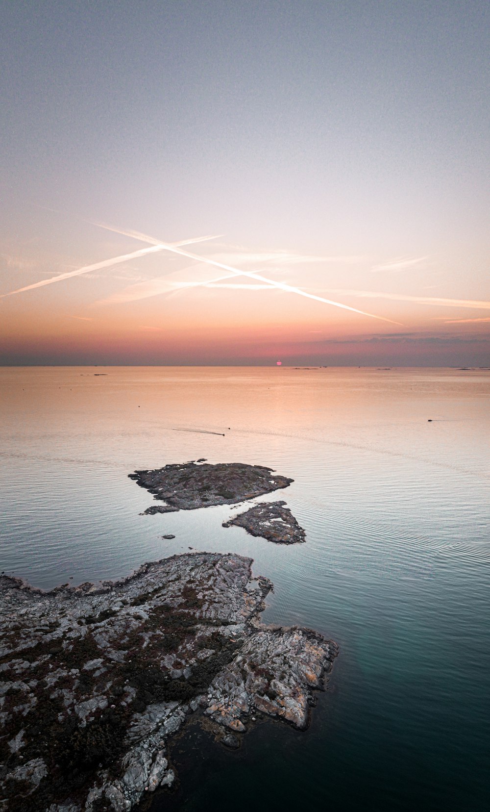 Formation rocheuse noire et grise sur le plan d’eau au coucher du soleil