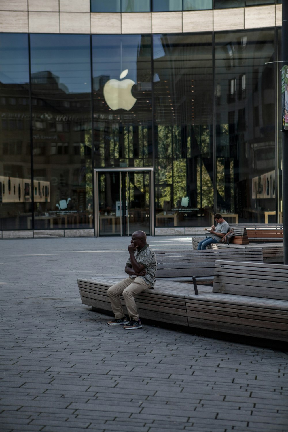 man in red jacket sitting on bench during daytime