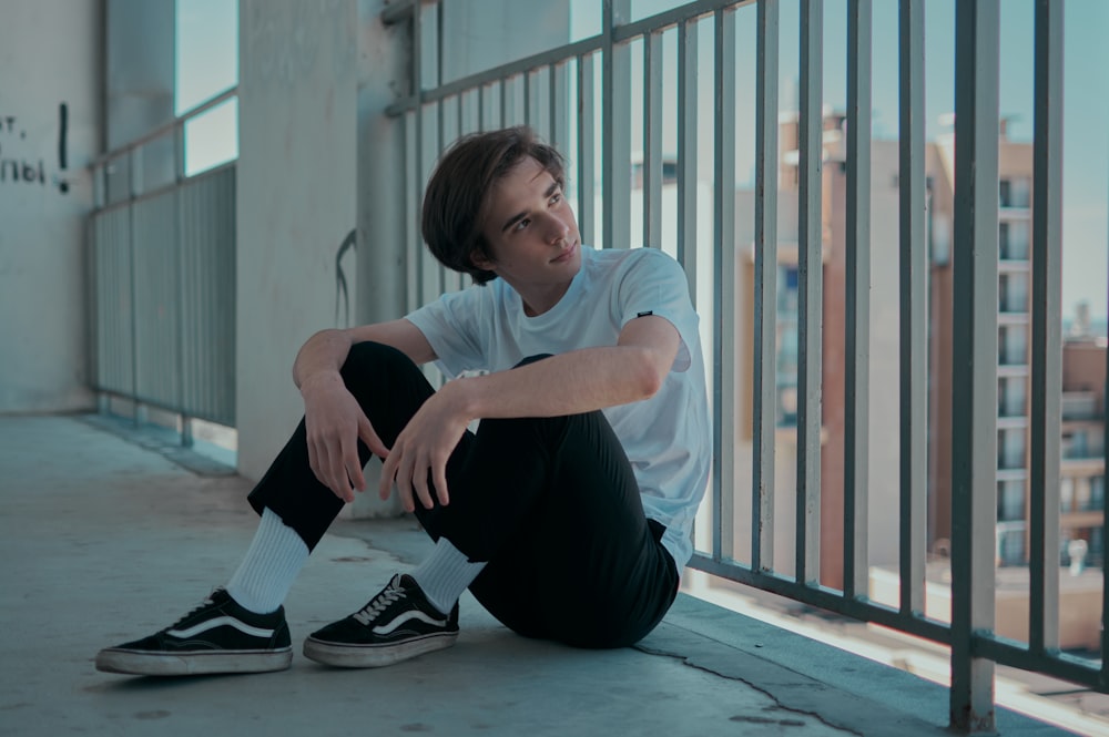 woman in white crew neck t-shirt and black pants sitting on floor