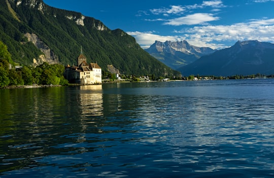 white concrete building on island surrounded by water in Château de Chillon Switzerland