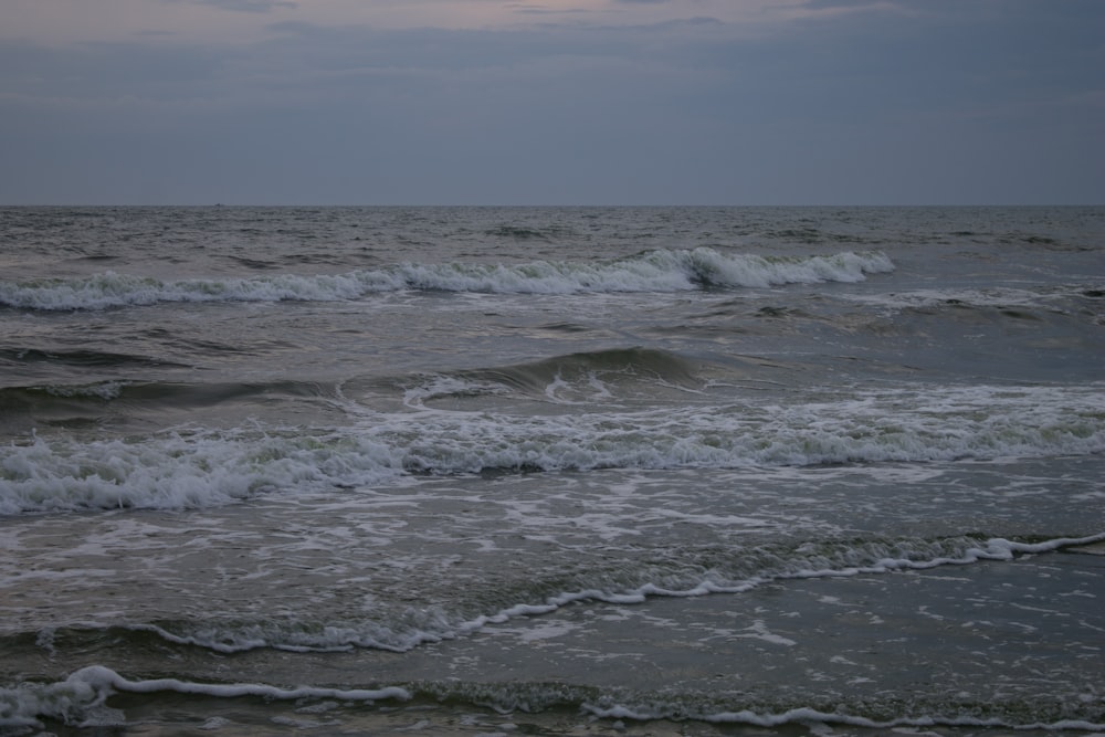 ocean waves under cloudy sky during daytime