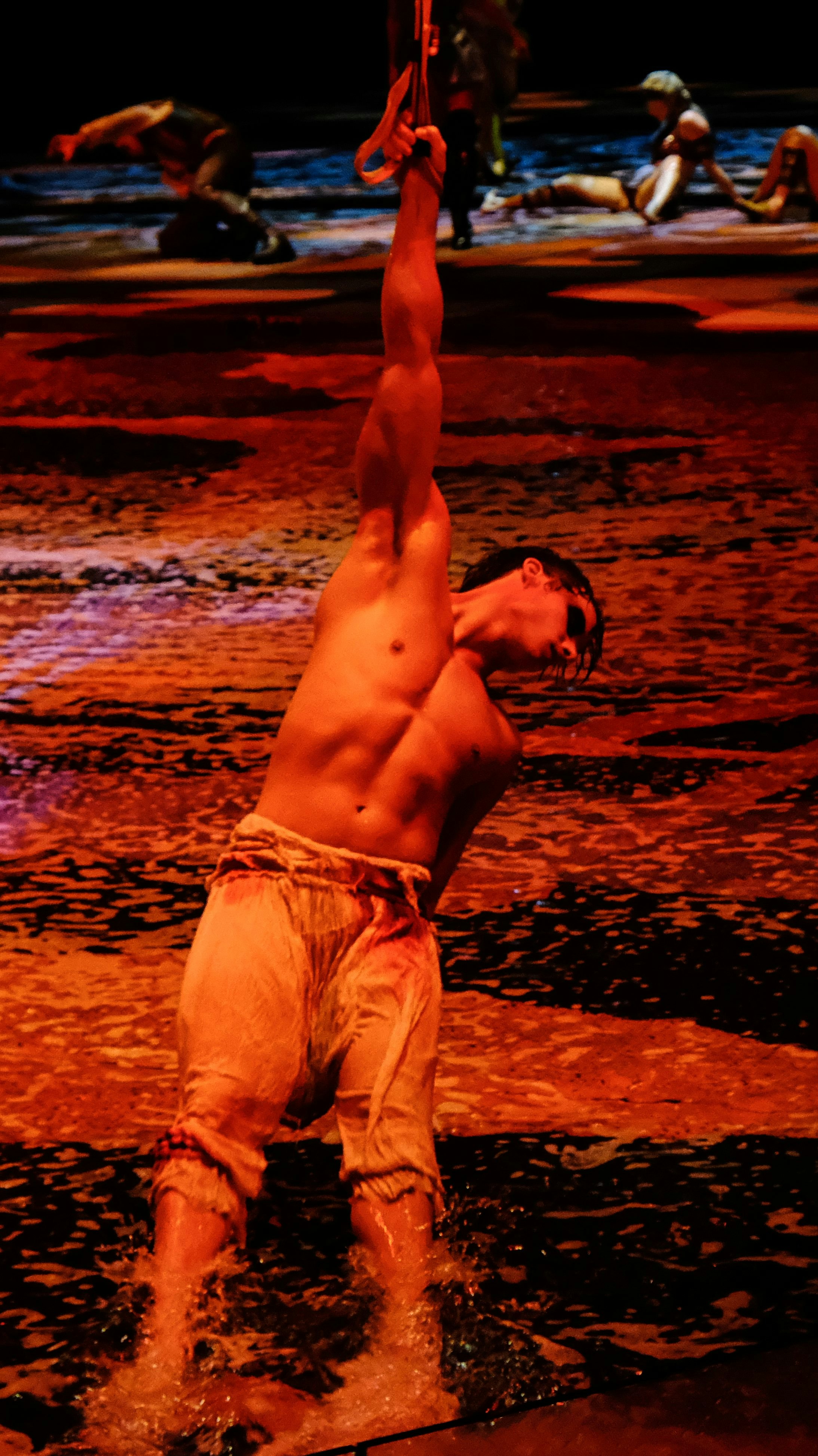 topless man in white shorts lying on beach shore during sunset