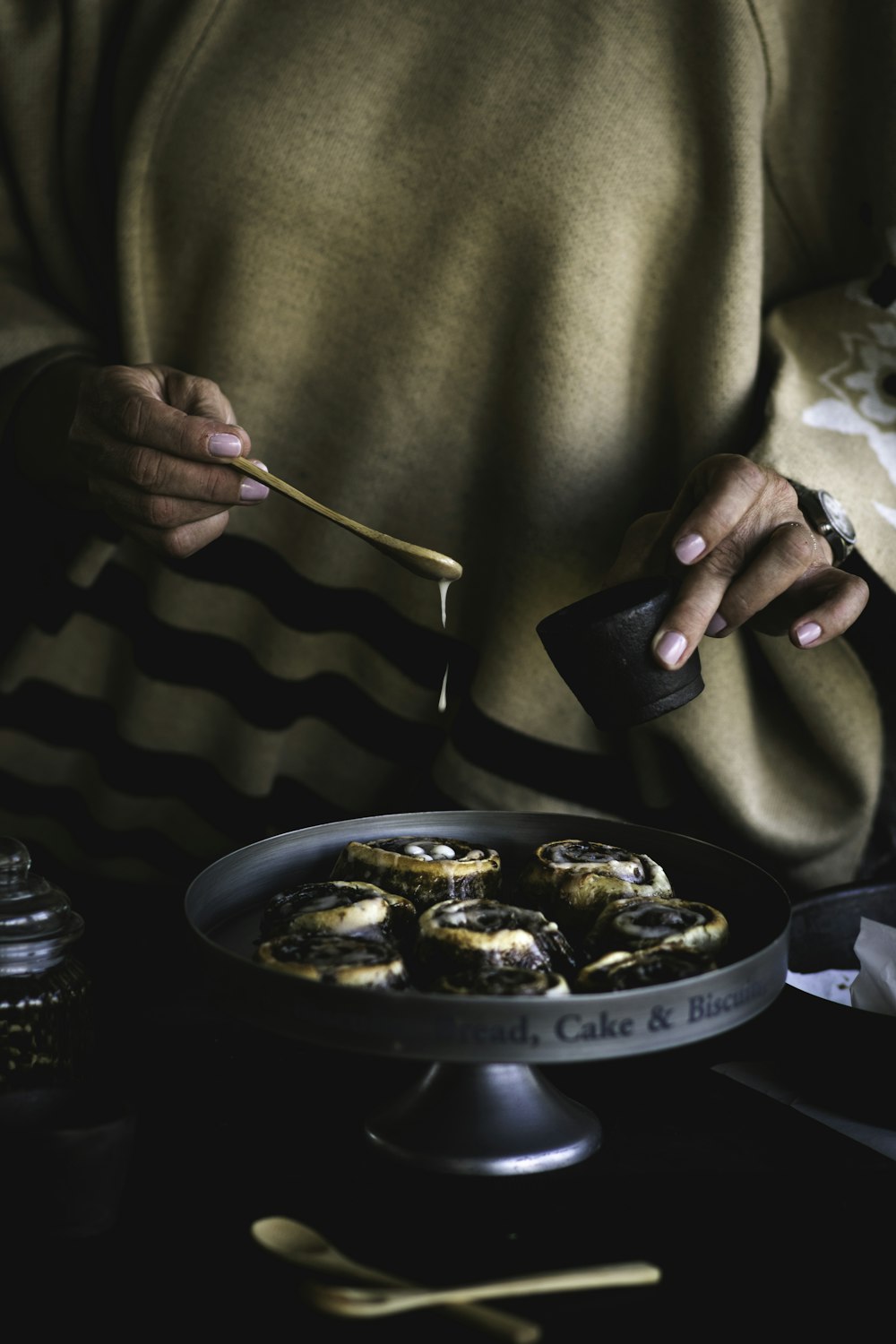 person holding chopsticks and round black ceramic plate