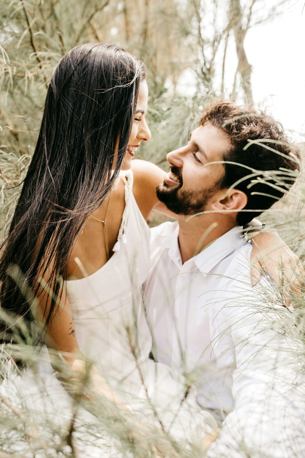 man and woman kissing on grass field during daytime