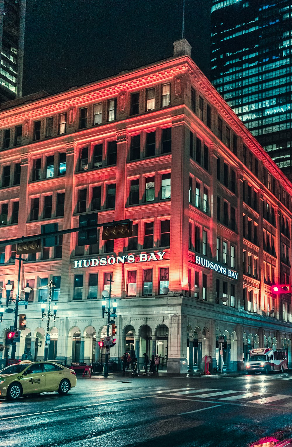 people walking on street near red concrete building during nighttime