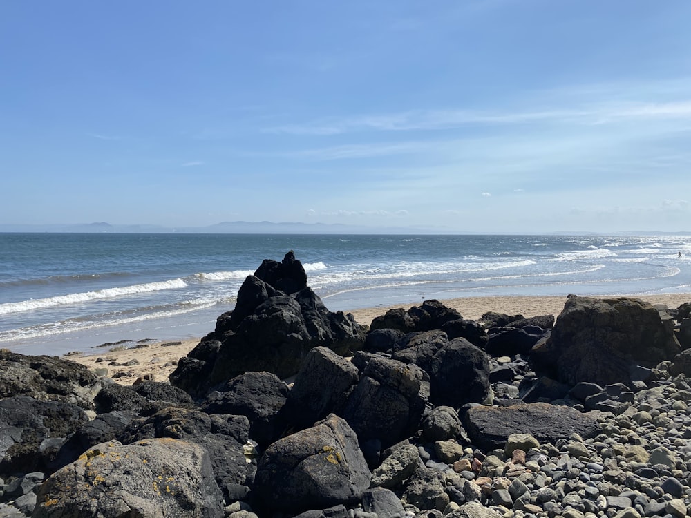 black rocks on seashore during daytime